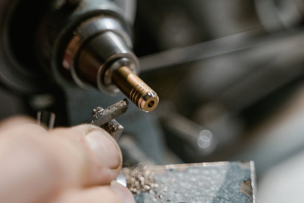 Detailed view of metalworking with a lathe in a workshop setting.
